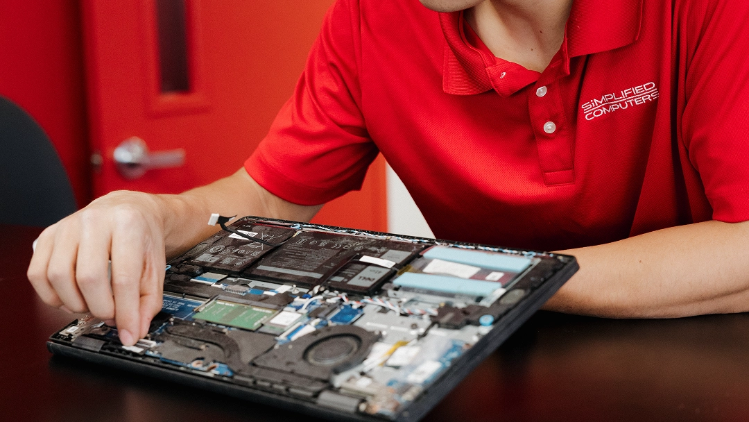 Technician performing internal laptop repair at Simplified Computers.