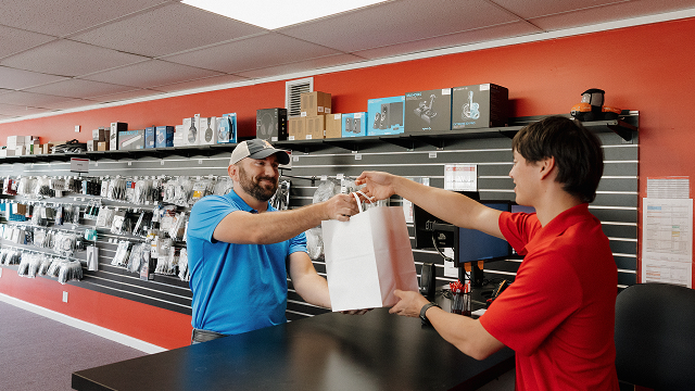 Simplified Computers team assisting a customer at the service counter.
